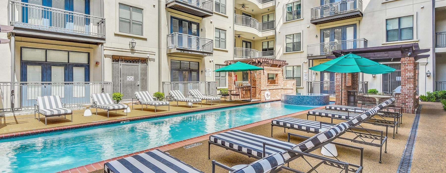 a pool with chairs and umbrellas